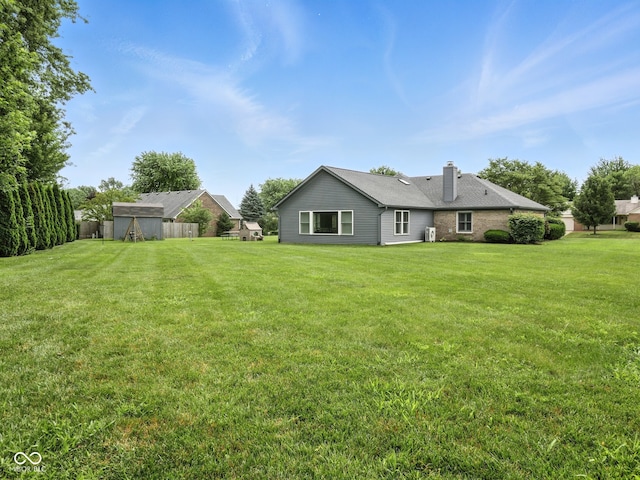 856 Cypress N, Greenwood, IN 46143 - rear view of house with a chimney and a yard