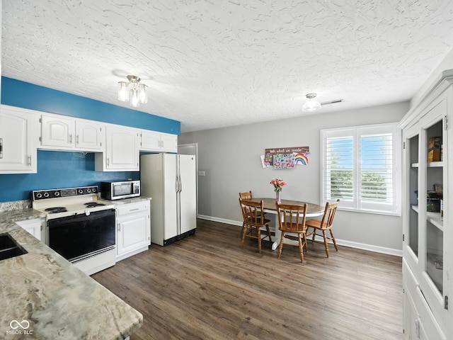 856 Cypress N, Greenwood, IN 46143 - kitchen featuring white appliances, dark wood-style floors, white cabinetry, light stone countertops, and a textured ceiling