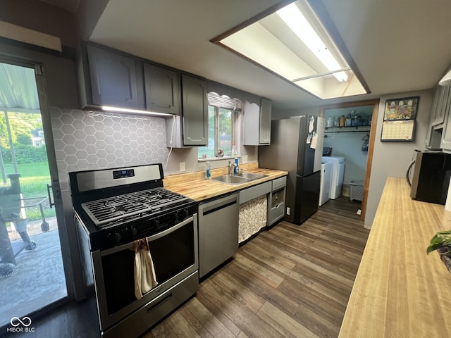 207 W Elm St, Spiceland, IN 47385 - kitchen with stainless steel appliances, independent washer and dryer, dark wood finished floors, wooden counters, and tasteful backsplash