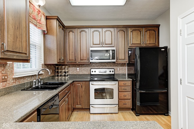 6813 Bluffgrove Dr, Indianapolis, IN 46278 - kitchen with black appliances, light wood-style flooring, and backsplash