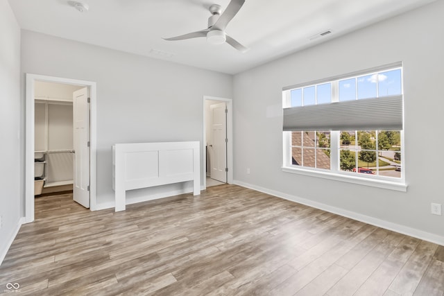 10795 Creekbed Cir, Fishers, IN 46038 - unfurnished bedroom featuring wood finished floors, a walk in closet, and a ceiling fan