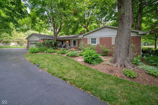 7224 N Tuxedo St, Indianapolis, IN 46240 - ranch-style home with brick siding, a chimney, driveway, an attached garage, and a front yard