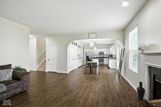 5664 Crump Ln, Indianapolis, IN 46234 - living room with a premium fireplace, dark wood finished floors, stairs, and arched walkways