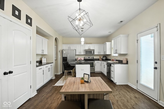5664 Crump Ln, Indianapolis, IN 46234 - kitchen featuring stainless steel appliances, dark wood-style floors, white cabinetry, dark countertops, and a kitchen island