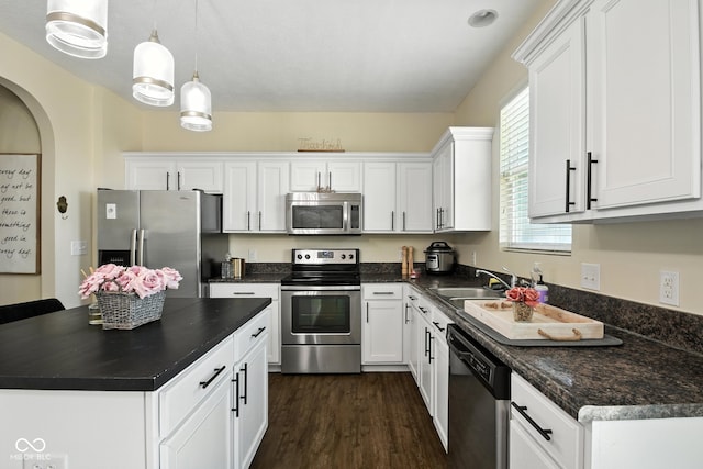 5664 Crump Ln, Indianapolis, IN 46234 - kitchen with appliances with stainless steel finishes, dark countertops, white cabinets, dark wood-style flooring, and a kitchen island