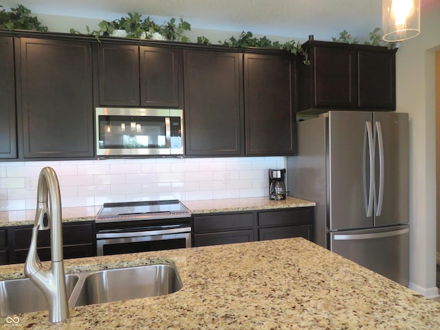 2272 Trefoil Dr, Plainfield, IN 46168 - kitchen featuring appliances with stainless steel finishes, dark brown cabinets, backsplash, and light stone counters