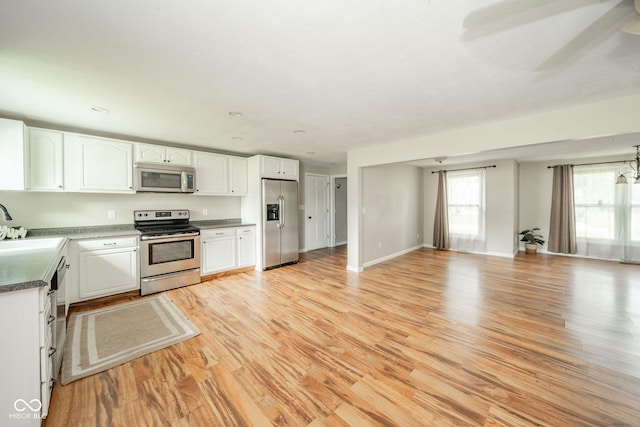 124 Bess Blvd, Pendleton, IN 46064 - kitchen with appliances with stainless steel finishes, white cabinets, open floor plan, and light wood-type flooring