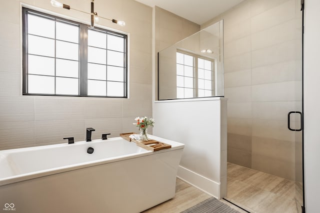 12022 Otto Ln, Carmel, IN 46032 - full bath with a soaking tub, a tile shower, and tile walls