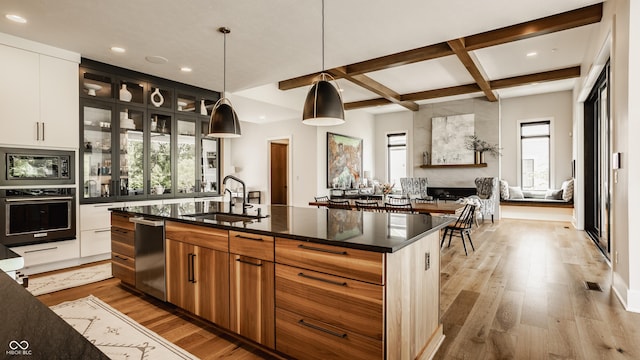 12022 Otto Ln, Carmel, IN 46032 - kitchen with appliances with stainless steel finishes, coffered ceiling, recessed lighting, light wood-style floors, and an island with sink