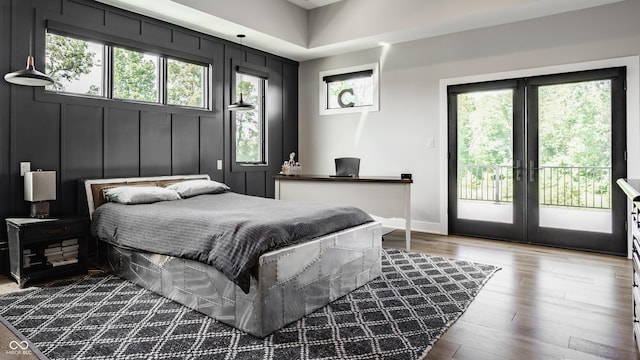 12022 Otto Ln, Carmel, IN 46032 - bedroom featuring access to exterior, wood finished floors, french doors, and a decorative wall