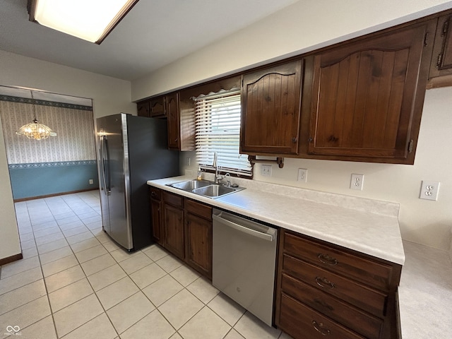 4675 N Riverside Dr, Columbus, IN 47203 - kitchen with stainless steel appliances, light countertops, light tile patterned floors, dark brown cabinetry, and pendant lighting