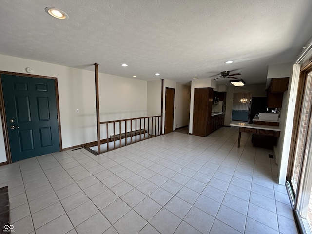 4675 N Riverside Dr, Columbus, IN 47203 - unfurnished living room with recessed lighting, a ceiling fan, light tile patterned floors, and a textured ceiling