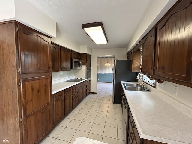 4675 N Riverside Dr, Columbus, IN 47203 - kitchen featuring stainless steel appliances, light countertops, light tile patterned floors, and dark brown cabinets