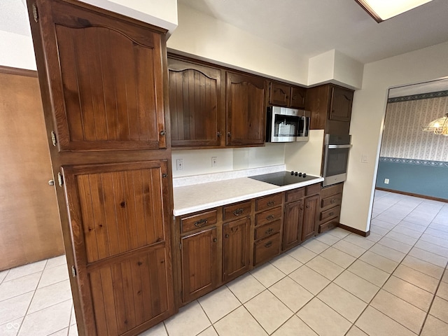4675 N Riverside Dr, Columbus, IN 47203 - kitchen featuring appliances with stainless steel finishes, light tile patterned floors, light countertops, and dark brown cabinets