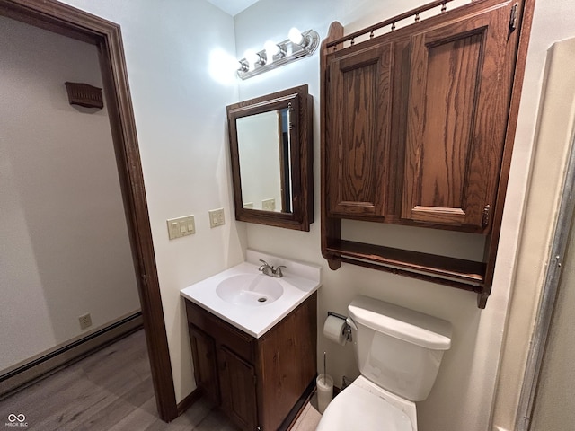 4675 N Riverside Dr, Columbus, IN 47203 - half bath with vanity, wood finished floors, and baseboard heating