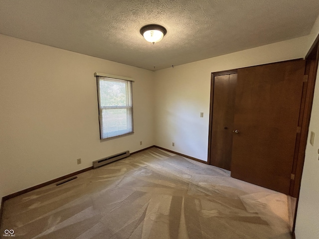 4675 N Riverside Dr, Columbus, IN 47203 - unfurnished bedroom featuring baseboard heating, light colored carpet, a textured ceiling, and a closet
