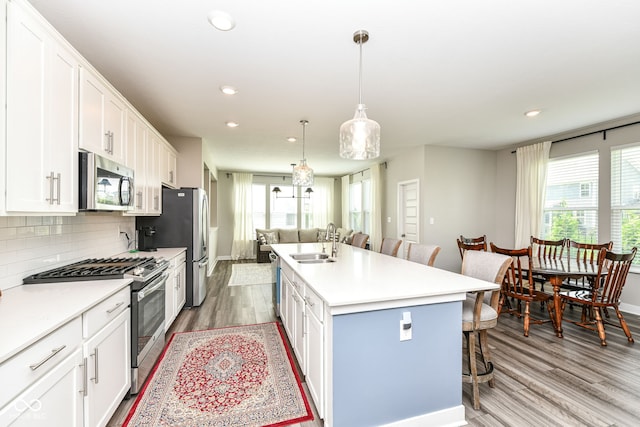 16502 Dominion Dr, Fishers, IN 46040 - kitchen with appliances with stainless steel finishes, a breakfast bar area, light wood-style flooring, white cabinetry, and recessed lighting