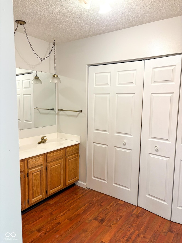 2770 Two Worlds Dr, Columbus, IN 47201 - bathroom with vanity, wood finished floors, and a textured ceiling