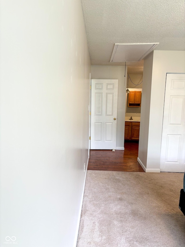 2770 Two Worlds Dr, Columbus, IN 47201 - hall featuring attic access, dark colored carpet, and a textured ceiling