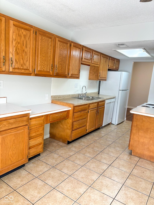2770 Two Worlds Dr, Columbus, IN 47201 - kitchen featuring white appliances, light countertops, brown cabinetry, and a textured ceiling