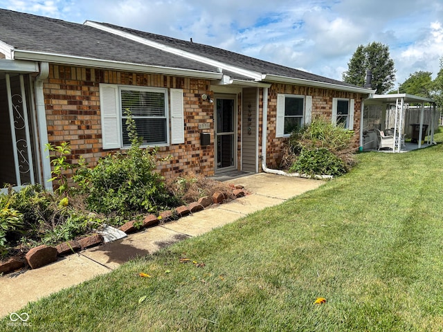 2770 Two Worlds Dr, Columbus, IN 47201 - property entrance featuring a lawn, brick siding, and a shingled roof
