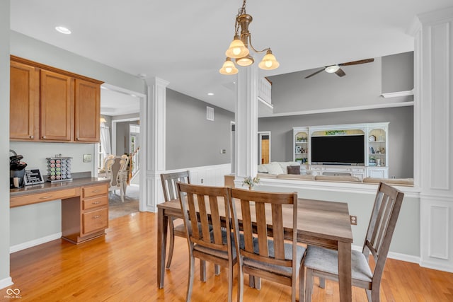 7830 Cross Crk, Avon, IN 46123 - dining space with a ceiling fan, built in desk, light wood-style flooring, decorative columns, and a wainscoted wall