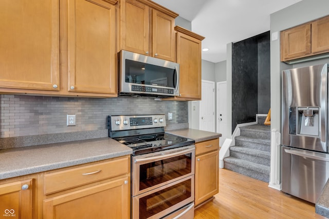 7830 Cross Crk, Avon, IN 46123 - kitchen with appliances with stainless steel finishes, backsplash, light wood-style flooring, and light countertops