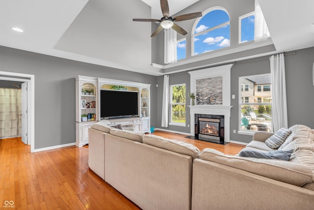 7830 Cross Crk, Avon, IN 46123 - living room with a ceiling fan, a fireplace with flush hearth, light wood-style flooring, a high ceiling, and recessed lighting
