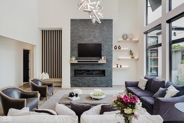 1269 Chatham Rdg Ct, Westfield, IN 46074 - living room featuring a towering ceiling, a chandelier, wood finished floors, and a stone fireplace