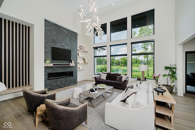 1269 Chatham Rdg Ct, Westfield, IN 46074 - living area featuring a towering ceiling, wood finished floors, a chandelier, and a stone fireplace