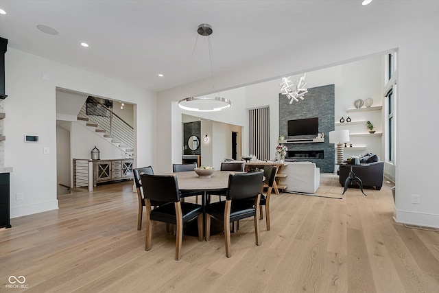 1269 Chatham Rdg Ct, Westfield, IN 46074 - dining space featuring a stone fireplace, light wood-style floors, stairway, recessed lighting, and a chandelier