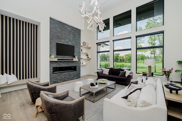 1269 Chatham Rdg Ct, Westfield, IN 46074 - living area with wood finished floors, a high ceiling, a fireplace, and a chandelier