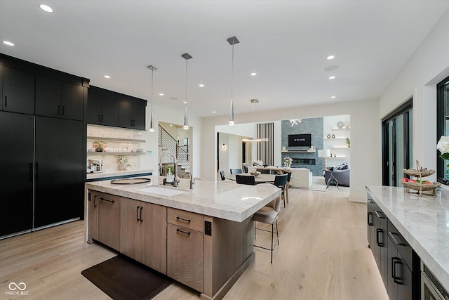 1269 Chatham Rdg Ct, Westfield, IN 46074 - kitchen featuring light wood-style floors, a large island with sink, open floor plan, modern cabinets, and a kitchen bar