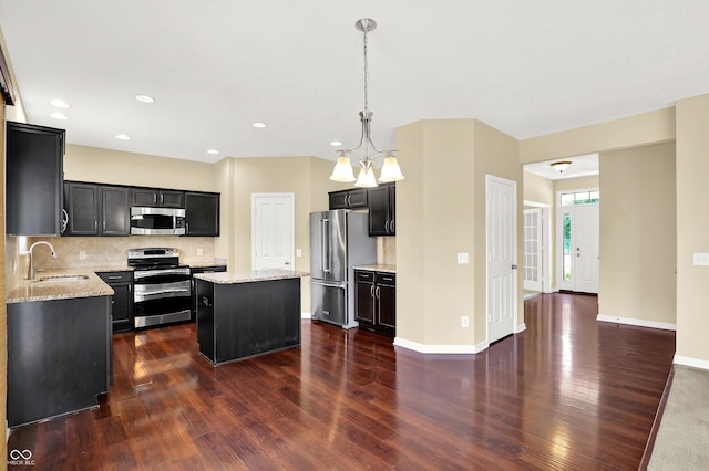 14095 Northcoat Pl, Fishers, IN 46038 - kitchen with stainless steel appliances, dark cabinetry, a center island, dark wood-style floors, and recessed lighting