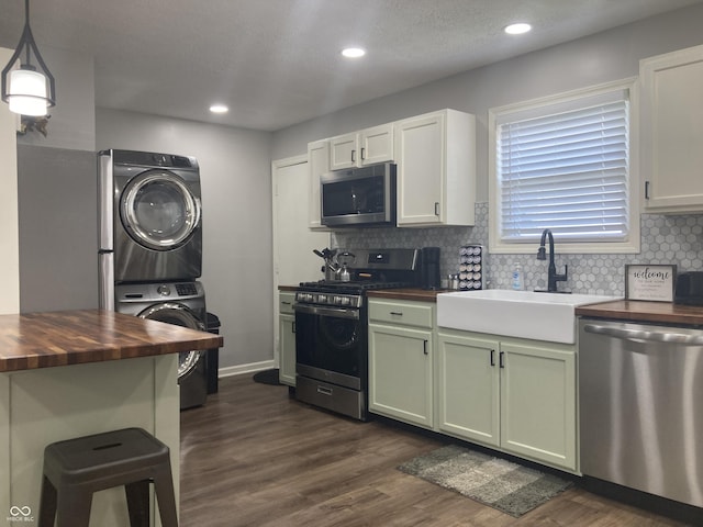2822 Tindall St, Indianapolis, IN 46203 - kitchen with wood counters, appliances with stainless steel finishes, stacked washer / drying machine, green cabinetry, and decorative backsplash
