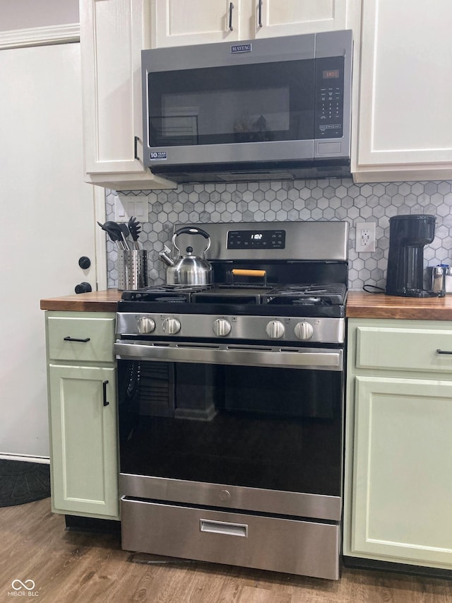 2822 Tindall St, Indianapolis, IN 46203 - kitchen with appliances with stainless steel finishes, butcher block countertops, green cabinetry, and backsplash