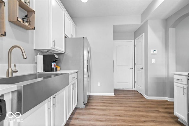 1158 Thistlewood Way, Plainfield, IN 46168 - kitchen featuring light wood-style floors, white cabinets, arched walkways, open shelves, and stainless steel fridge