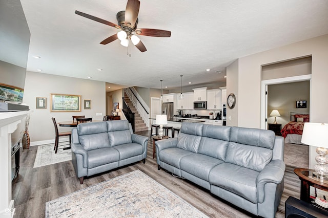 1432 Hideaway Cir, Brownsburg, IN 46112 - living room with stairs, a ceiling fan, dark wood-type flooring, and recessed lighting