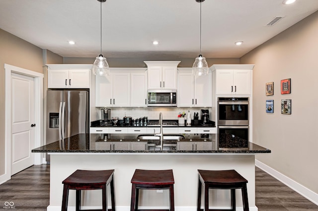 1432 Hideaway Cir, Brownsburg, IN 46112 - kitchen featuring appliances with stainless steel finishes, a kitchen island with sink, dark wood finished floors, backsplash, and white cabinetry