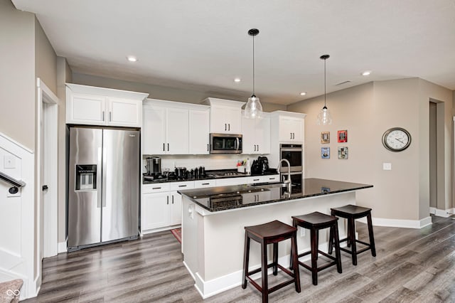1432 Hideaway Cir, Brownsburg, IN 46112 - kitchen with stainless steel appliances, dark wood-style flooring, a kitchen island with sink, white cabinetry, and a kitchen bar