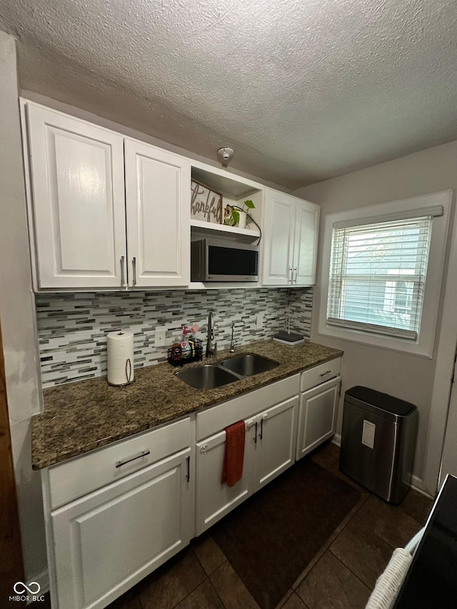 3711 Hillside Ave, Indianapolis, IN 46218 - kitchen with white cabinetry, stainless steel microwave, backsplash, a textured ceiling, and open shelves