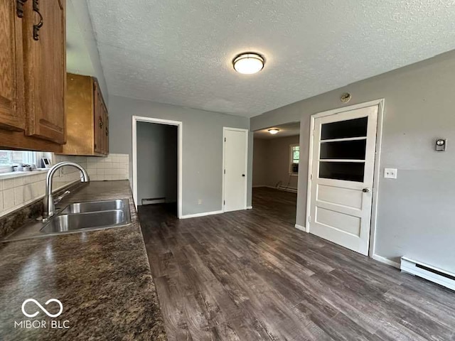 1941 W Booe Rd, Austin, IN 47102 - kitchen with brown cabinets, a textured ceiling, dark countertops, dark wood-style flooring, and backsplash