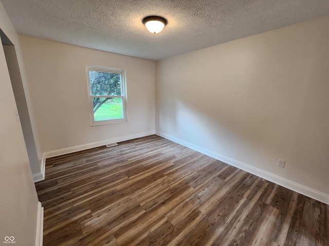 4536 Clayburn Dr, Indianapolis, IN 46268 - unfurnished room with dark wood-style flooring and a textured ceiling