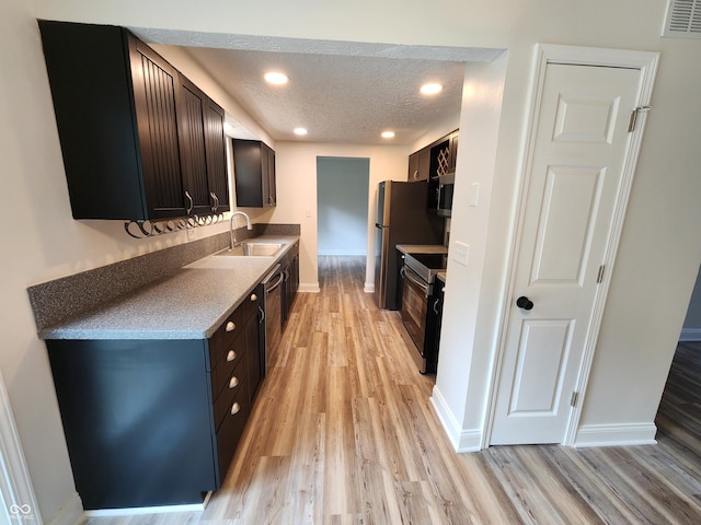 4536 Clayburn Dr, Indianapolis, IN 46268 - kitchen featuring appliances with stainless steel finishes, light wood-style floors, a textured ceiling, recessed lighting, and dark brown cabinets