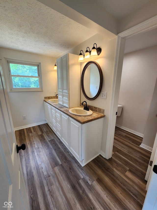 4536 Clayburn Dr, Indianapolis, IN 46268 - bathroom with wood finished floors, double vanity, and a textured ceiling