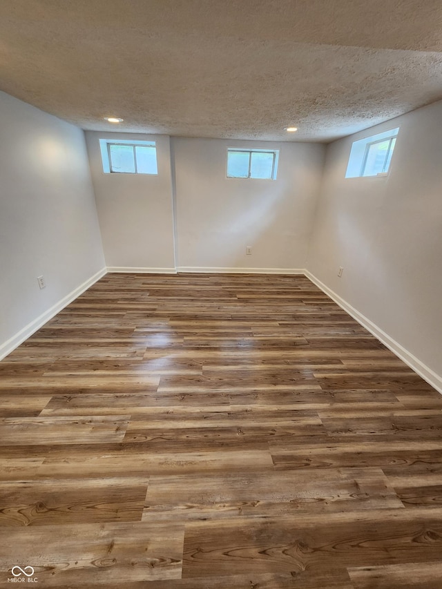 4536 Clayburn Dr, Indianapolis, IN 46268 - basement featuring wood finished floors, a textured ceiling, healthy amount of natural light, and recessed lighting