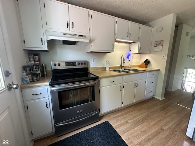 7607 Ardwell Ct, Indianapolis, IN 46237 - kitchen with electric stove, under cabinet range hood, light countertops, light wood-style flooring, and white cabinets