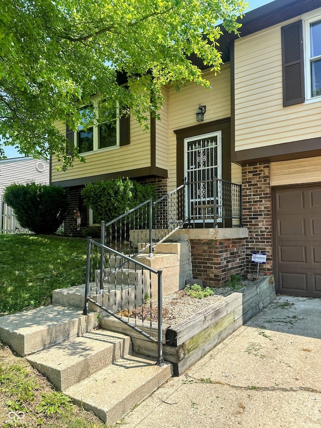 7607 Ardwell Ct, Indianapolis, IN 46237 - doorway to property with an attached garage, brick siding, and driveway