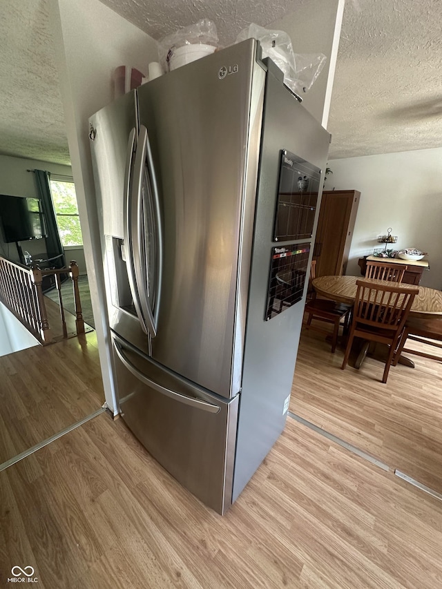 7607 Ardwell Ct, Indianapolis, IN 46237 - kitchen featuring stainless steel refrigerator with ice dispenser, a textured ceiling, and light wood-style flooring
