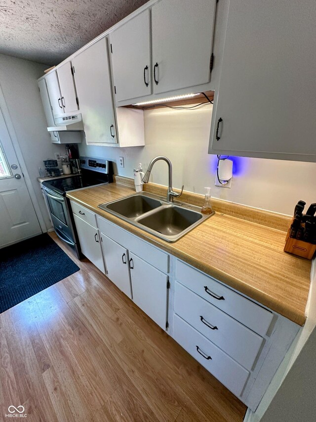 7607 Ardwell Ct, Indianapolis, IN 46237 - kitchen featuring stainless steel electric range oven, wood finished floors, white cabinets, light countertops, and a textured ceiling